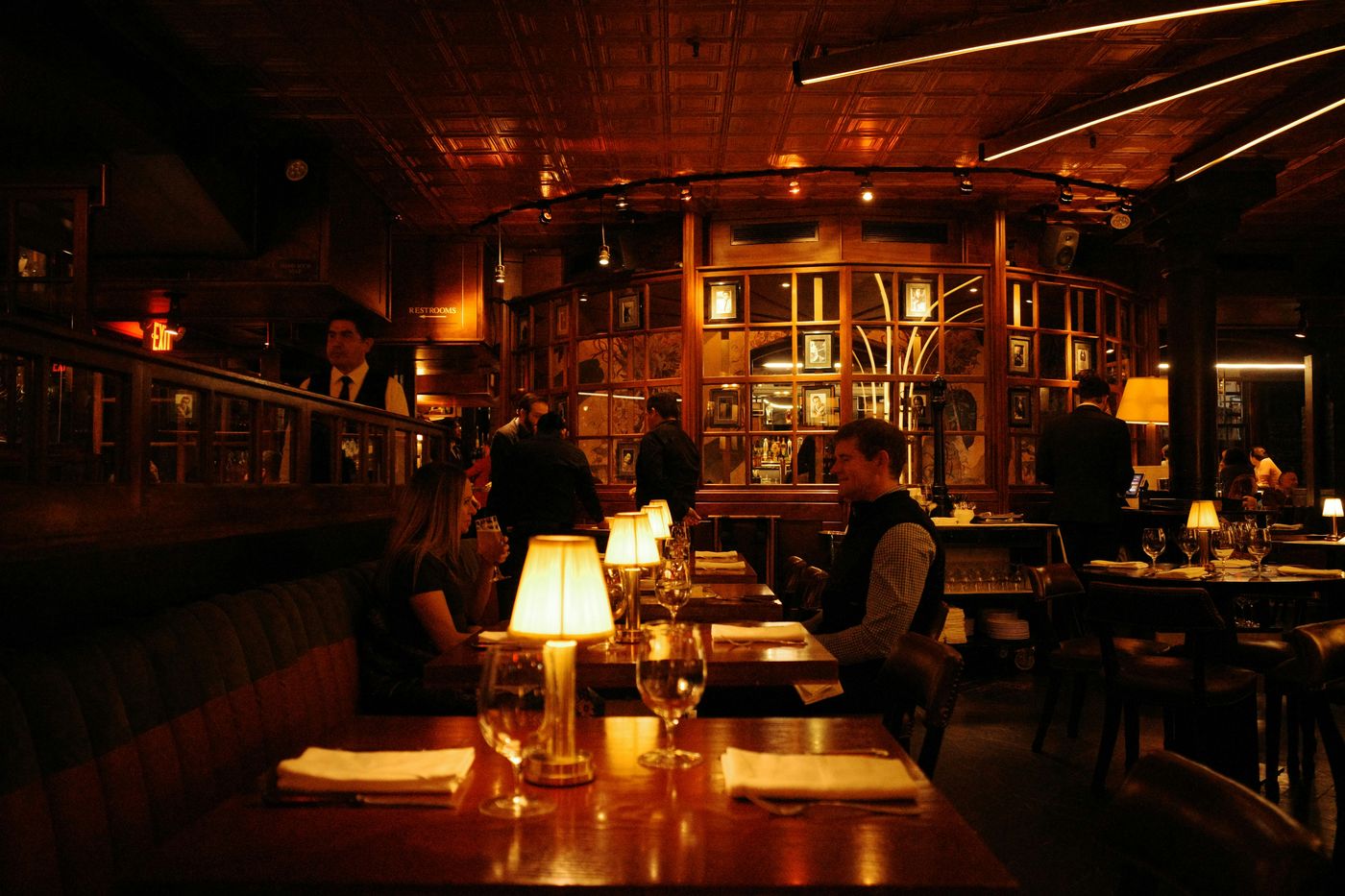 Guests dining in the warm, low-lit main room at Noir House