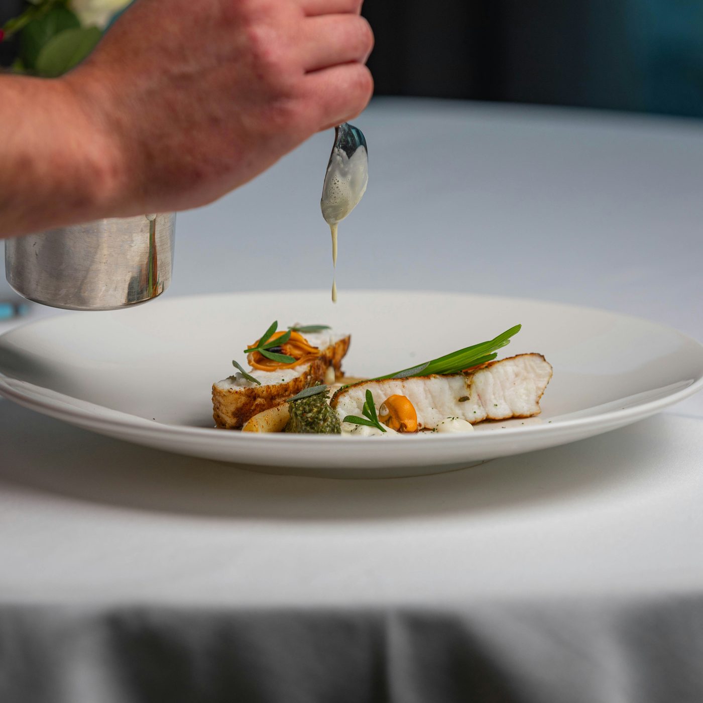 A place setting on white ceramic at Noir House